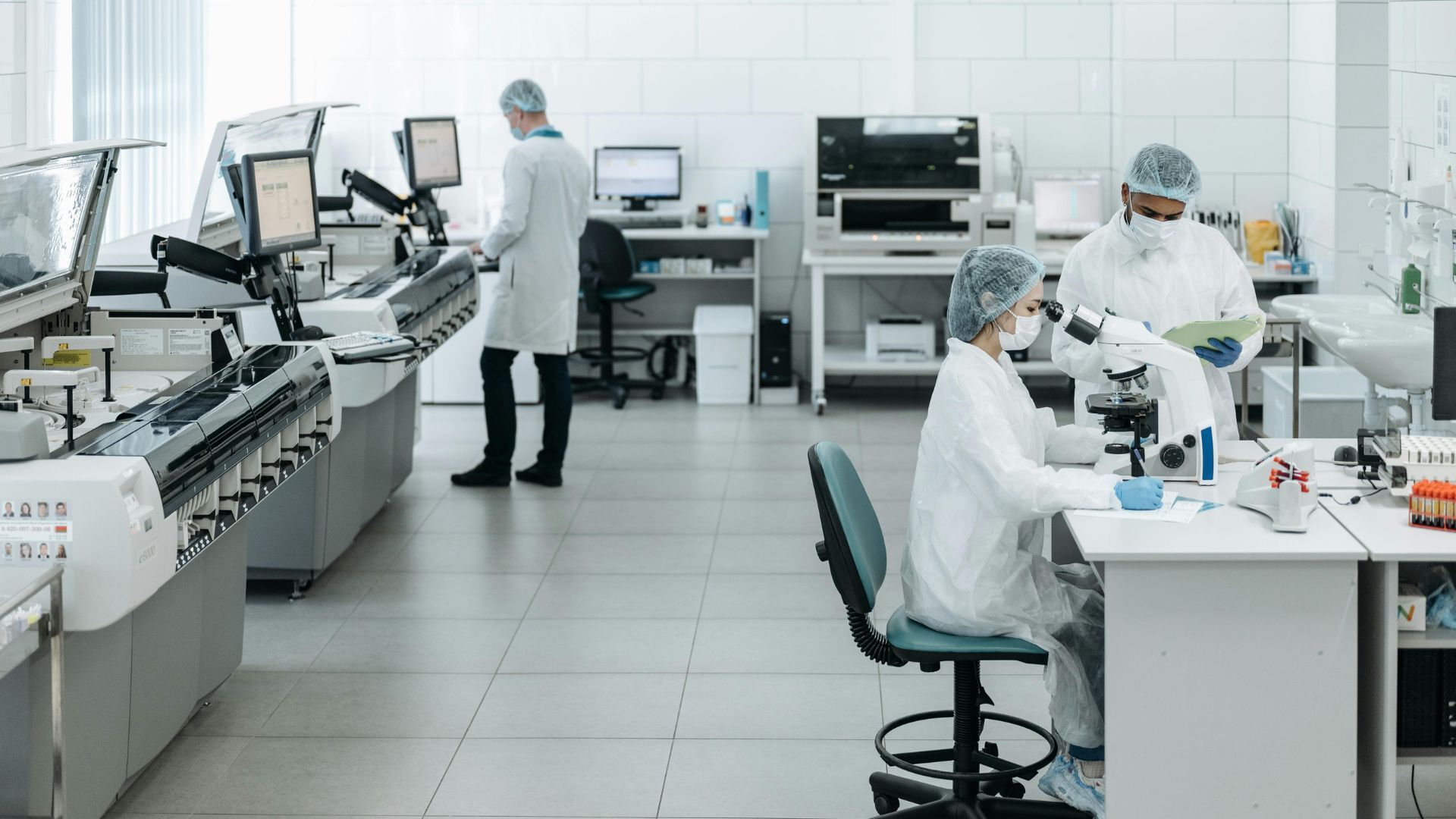 Researchers in lab coats performing experiments with advanced equipment in a laboratory.