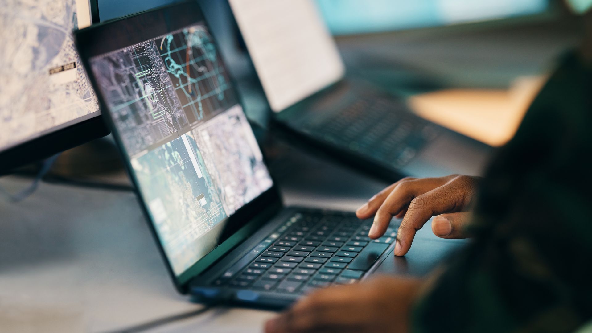 Close-up of a person’s hands typing on a laptop, working on a cybersecurity task