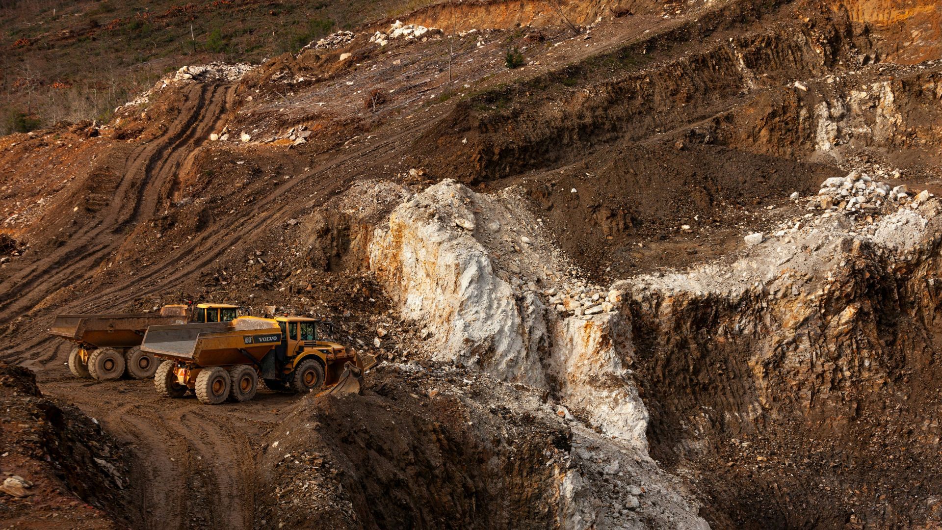 Large trucks on dirt road.