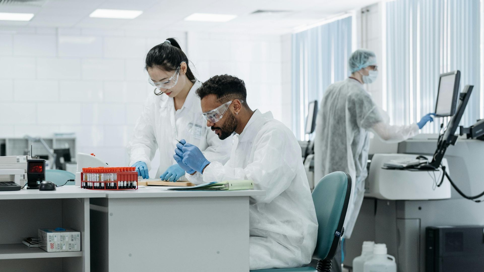 A laboratory scene with scientists handling samples and using computers